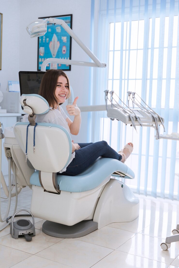 smiling-female-patient-sitting-chair-showing-thumb-up-dental-clinic_23-2147879168